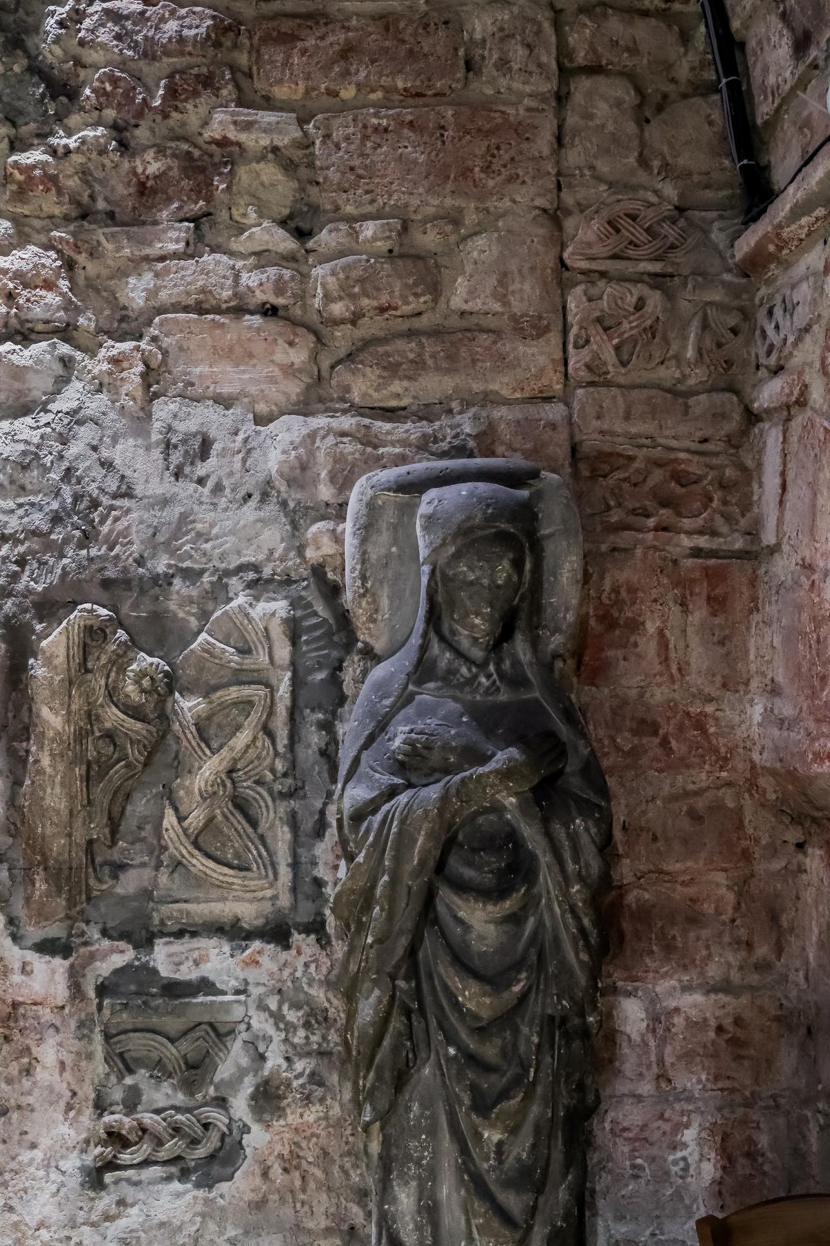 Gisant du XIVe siècle dans la crypte avec aux murs ce qu'il reste de la chapelle carolingienne.